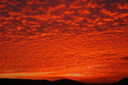 Někdy až kýčovité západy Slunce s oblohou pokrytou červánky bývají vděčným motivem fotografií. Zdroj: http://www.flickr.com.